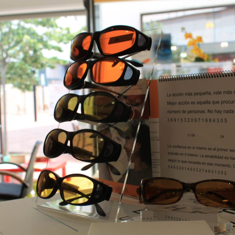 Siete gafas con diferentes tonalidades y filtros utilizadas como ayudas ópticas en baja visión.