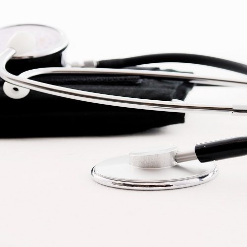 Fonendoscopio y tensiómetro sobre superficie blanca.